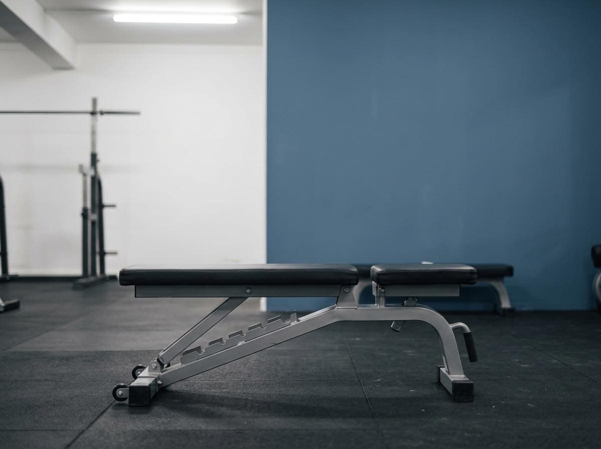 Leere Hantelbank in einem nüchternen Trainingsraum bei Hallenlicht
